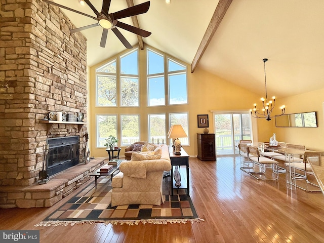 477 Wampum Ln, Hedgesville, WV 25427 - living room featuring wood-type flooring, beam ceiling, a stone fireplace, high vaulted ceiling, and ceiling fan with notable chandelier