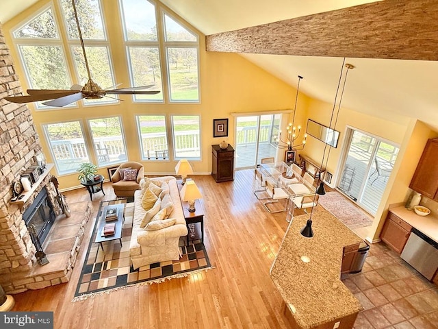 477 Wampum Ln, Hedgesville, WV 25427 - living area with a fireplace, baseboards, high vaulted ceiling, light wood-style flooring, and ceiling fan with notable chandelier