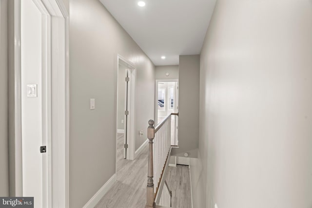 hall featuring recessed lighting, baseboards, an upstairs landing, and light wood-style floors