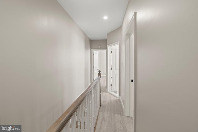 hallway featuring recessed lighting, an upstairs landing, light wood-type flooring, and baseboards