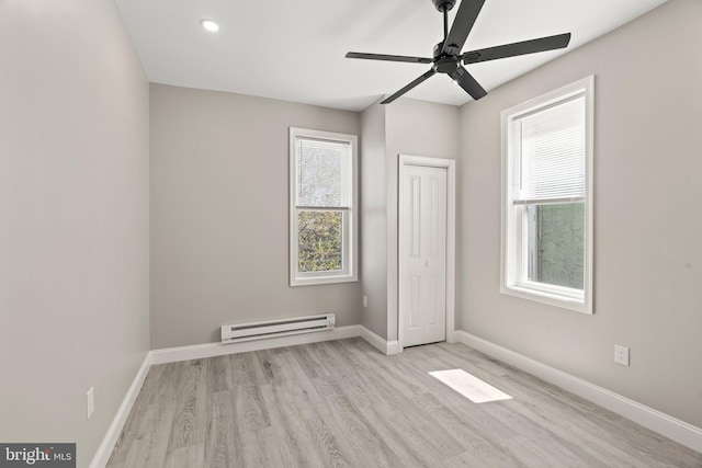 unfurnished bedroom featuring a closet, recessed lighting, wood finished floors, a baseboard radiator, and baseboards