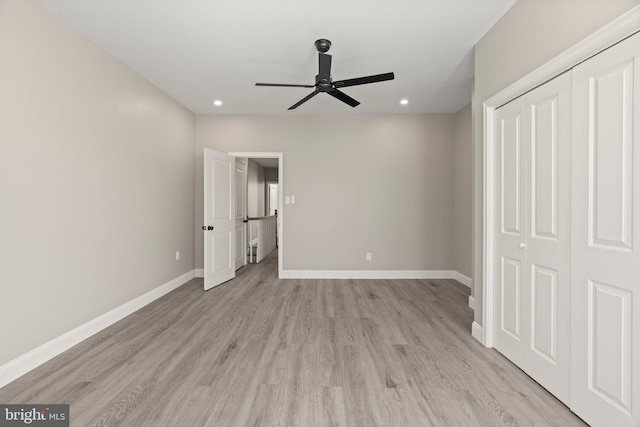 unfurnished bedroom with a closet, baseboards, and light wood-style floors