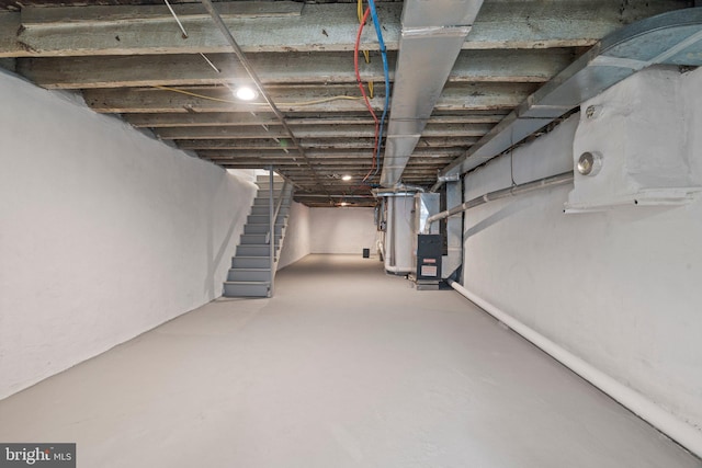 unfinished basement with heating unit and stairs