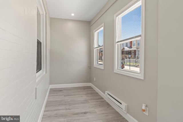 hall featuring recessed lighting, baseboard heating, light wood-type flooring, and baseboards
