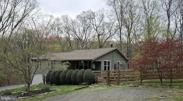 ranch-style house with fence and a shingled roof