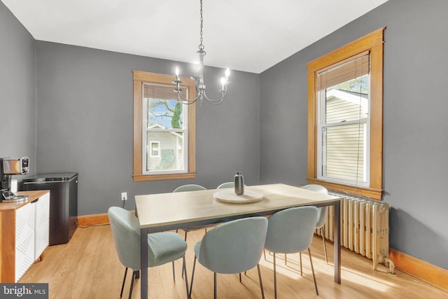 dining room featuring light wood finished floors, a notable chandelier, radiator heating unit, and baseboards