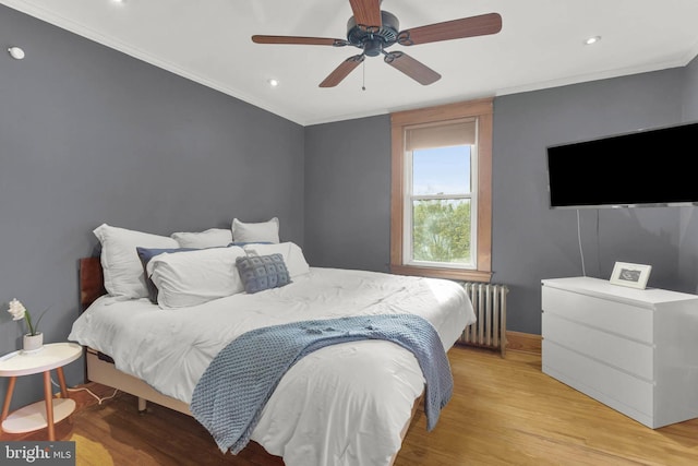 bedroom with recessed lighting, light wood-style flooring, radiator heating unit, ornamental molding, and baseboards