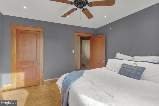 bedroom featuring a ceiling fan, light wood-style flooring, crown molding, and baseboards