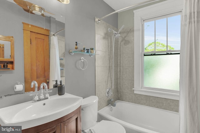 bathroom featuring toilet, shower / bath combination with curtain, and vanity