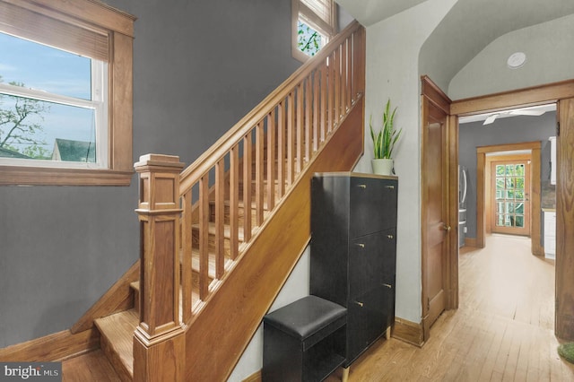 stairs with wood finished floors and baseboards
