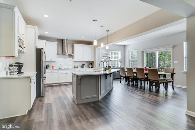 13301 Windjammer Ct, Hughesville, MD 20637 - kitchen featuring wall chimney exhaust hood, light countertops, a sink, and dark wood-style flooring