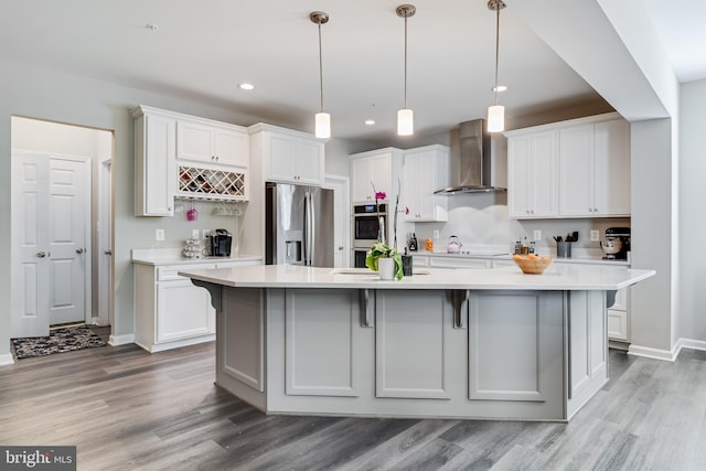 13301 Windjammer Ct, Hughesville, MD 20637 - kitchen with wall chimney exhaust hood, baseboards, light wood-style floors, and appliances with stainless steel finishes