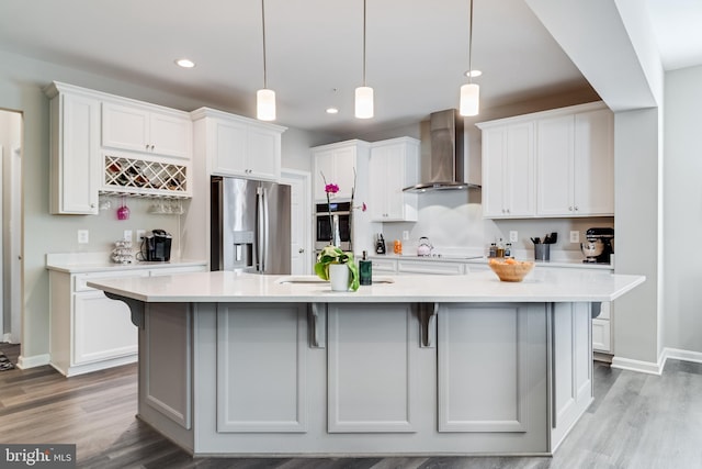 13301 Windjammer Ct, Hughesville, MD 20637 - kitchen featuring wall chimney range hood, stainless steel fridge with ice dispenser, a large island with sink, and light countertops
