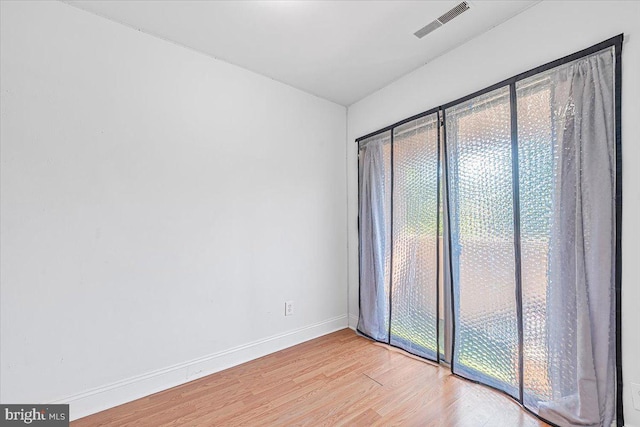 spare room with baseboards, visible vents, and light wood-type flooring