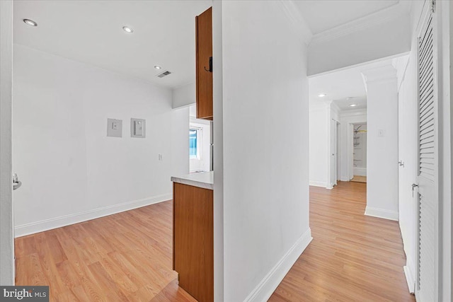 corridor featuring recessed lighting, baseboards, light wood-type flooring, visible vents, and ornamental molding