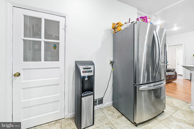 kitchen featuring light tile patterned floors and freestanding refrigerator