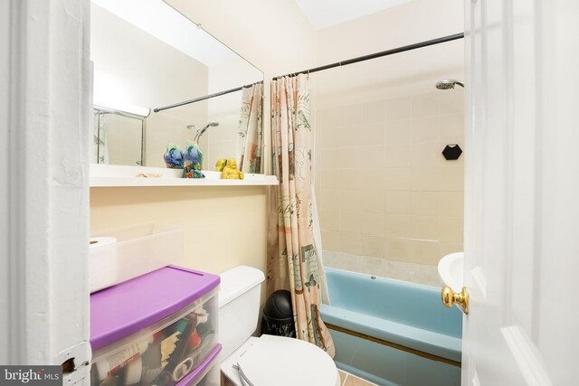 bathroom featuring toilet and shower / tub combo with curtain