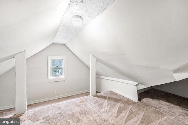 additional living space featuring carpet flooring, baseboards, and lofted ceiling