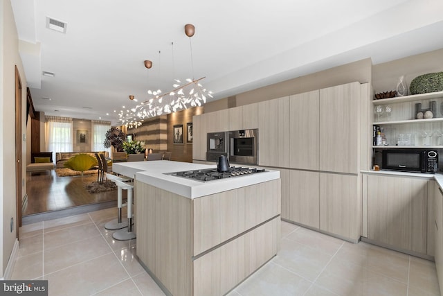 1227 S St NW, Washington, DC 20009 - kitchen with black microwave, light tile patterned flooring, visible vents, modern cabinets, and stainless steel gas stovetop