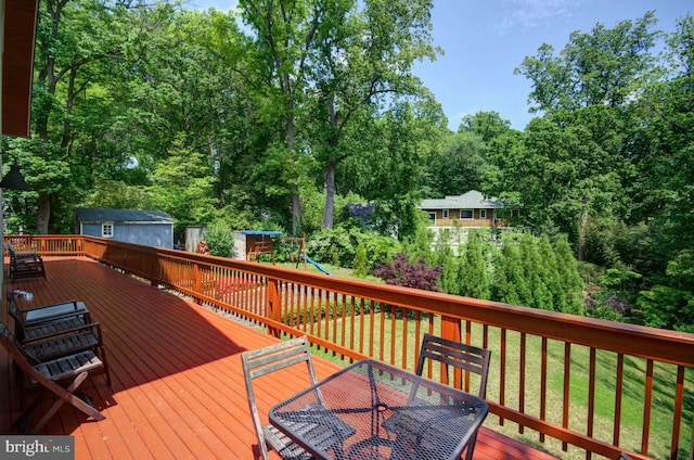 6525 76th St, Cabin John, MD 20818 - deck featuring outdoor dining space, a playground, and view of scattered trees