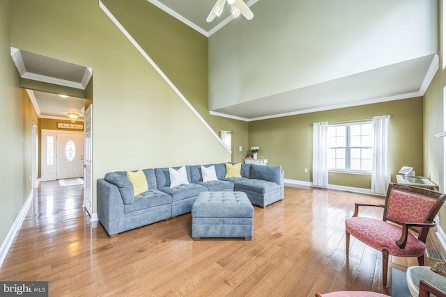 living area featuring light wood-type flooring, ornamental molding, and plenty of natural light