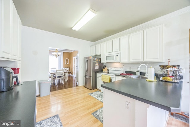kitchen with light wood-style flooring, white appliances, a sink, and white cabinetry