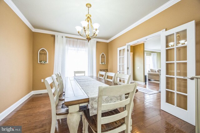 dining area with an inviting chandelier, baseboards, ornamental molding, and french doors