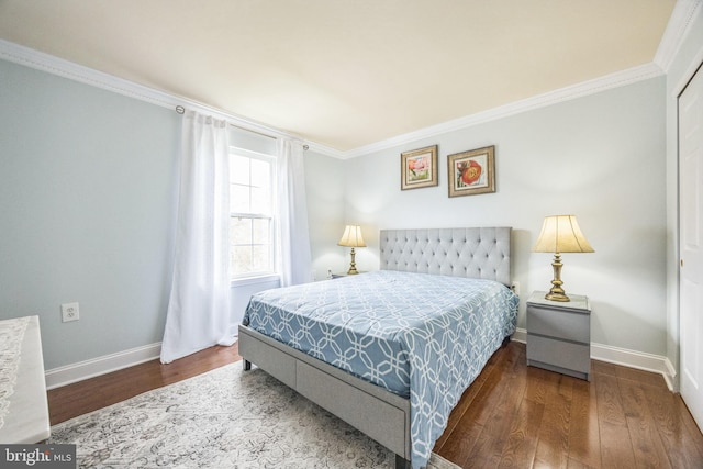 bedroom with wood finished floors, crown molding, and baseboards
