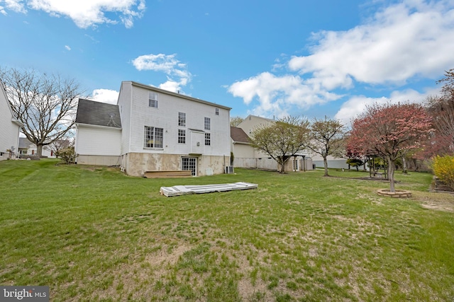 rear view of property with a yard