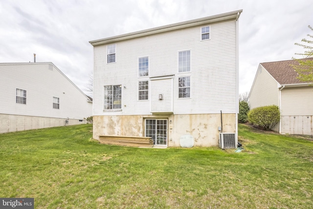 rear view of house with cooling unit and a lawn