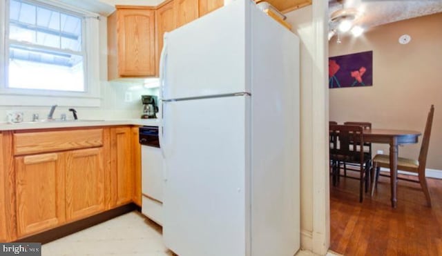 5010 54th Pl, Hyattsville, MD 20781 - kitchen with light wood-style floors, white appliances, light countertops, and a sink