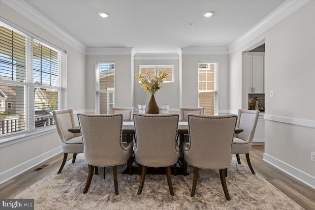 dining area with crown molding, baseboards, and wood finished floors