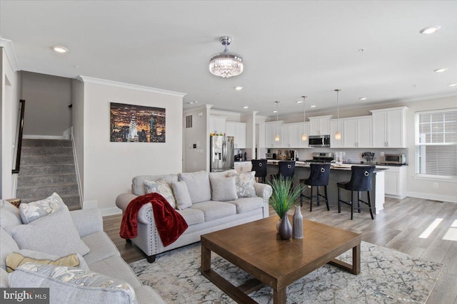 living area with light wood-type flooring, baseboards, ornamental molding, and recessed lighting