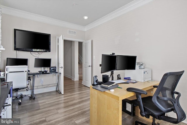office with crown molding, baseboards, visible vents, and light wood-type flooring