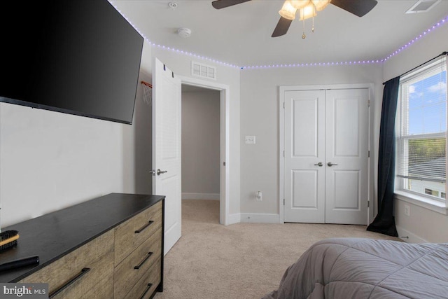 bedroom featuring a closet, light colored carpet, baseboards, and visible vents
