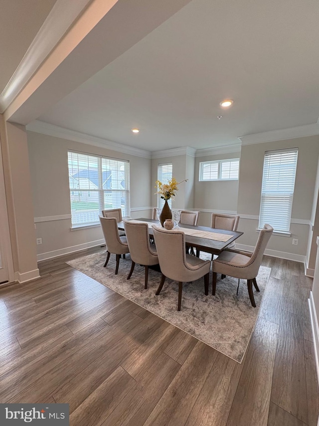 dining area featuring crown molding, baseboards, and dark wood finished floors