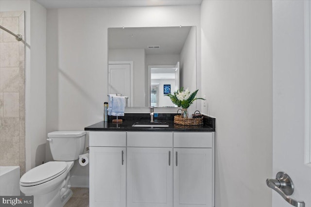 bathroom featuring vanity, visible vents, toilet, walk in shower, and baseboards
