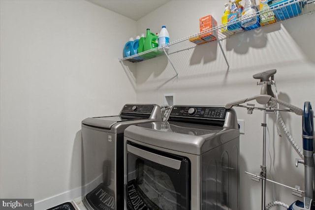 laundry area with baseboards, laundry area, and washing machine and clothes dryer