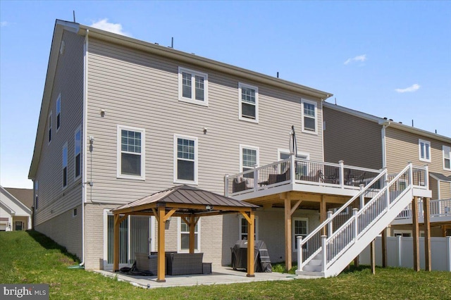 back of property with a lawn, a patio area, fence, brick siding, and a gazebo