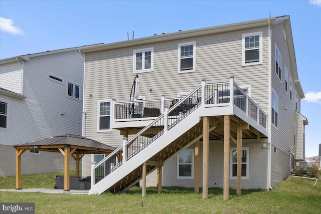 rear view of property with a gazebo, stairway, a deck, and a lawn
