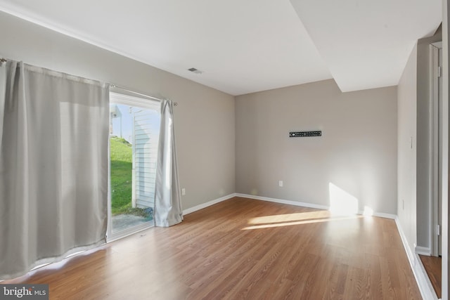 spare room featuring wood finished floors and baseboards