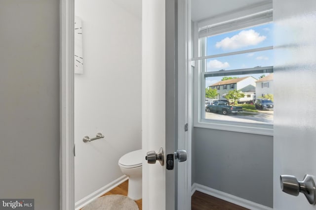 bathroom featuring wood finished floors, toilet, and baseboards