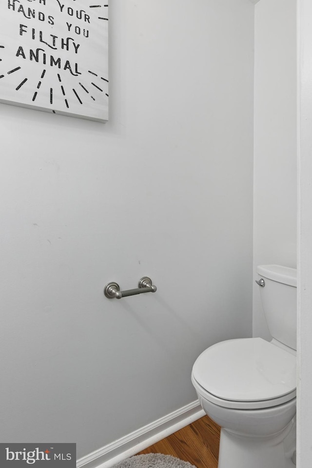bathroom featuring wood finished floors, toilet, and baseboards