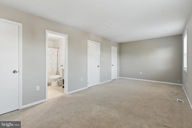 unfurnished bedroom featuring carpet, connected bathroom, and baseboards