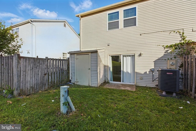 rear view of house featuring central AC unit, a storage shed, and an outdoor structure
