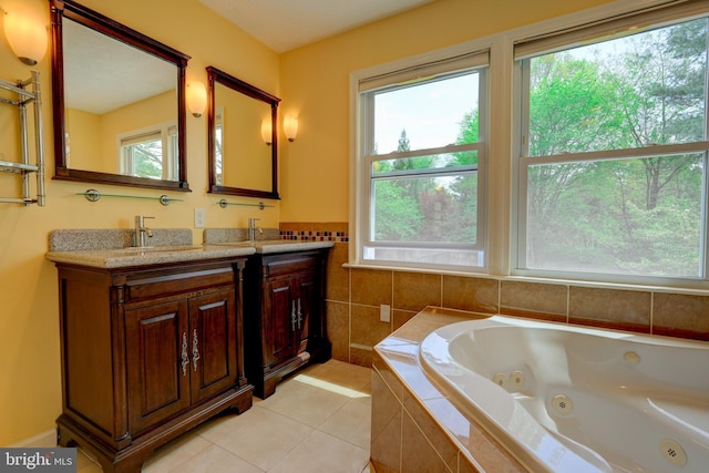 bathroom featuring tile patterned flooring, a sink, double vanity, and a tub with jets