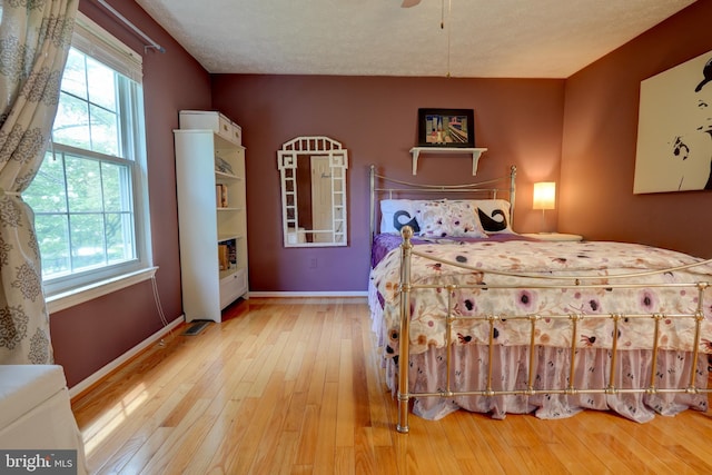 bedroom with hardwood / wood-style floors and baseboards