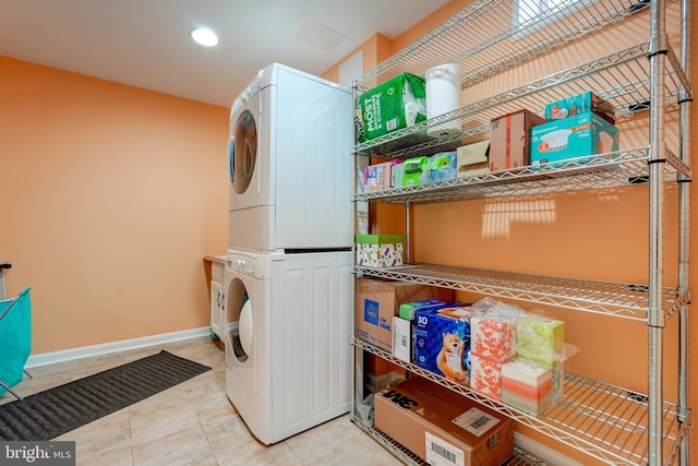 laundry area featuring tile patterned floors, stacked washer / drying machine, baseboards, laundry area, and recessed lighting