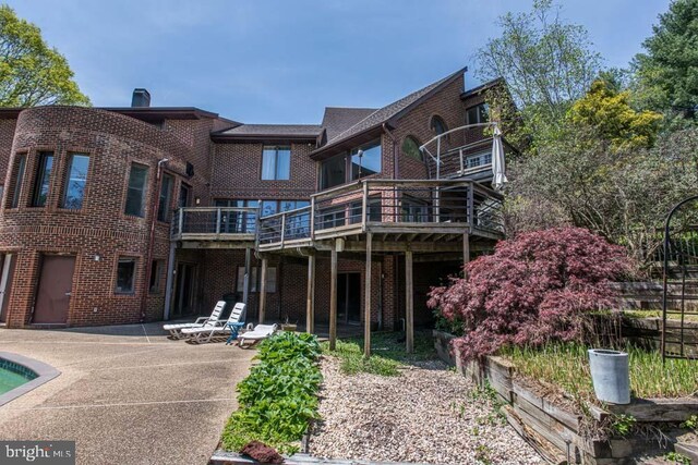 1 Fox Field Ct, Reisterstown, MD 21136 - rear view of house with brick siding, a swimming pool, a wooden deck, and a patio