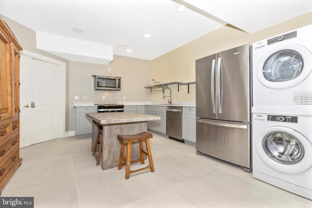 4083 Reels Mill Rd, Frederick, MD 21704 - kitchen with stacked washer / drying machine, stainless steel appliances, a sink, gray cabinetry, and light countertops